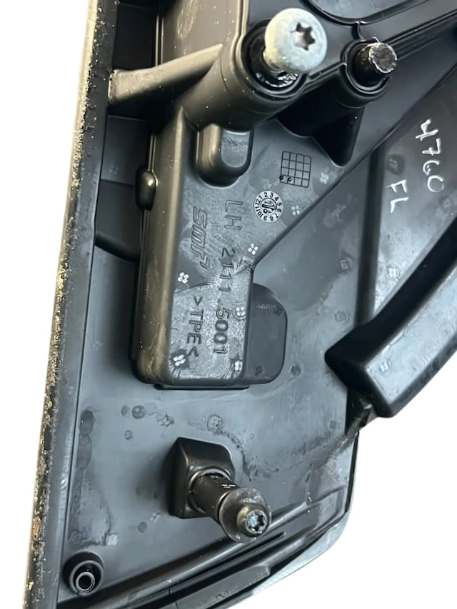 Left Mirror assembly underside showing three mounting studs and plastic housing with part markings