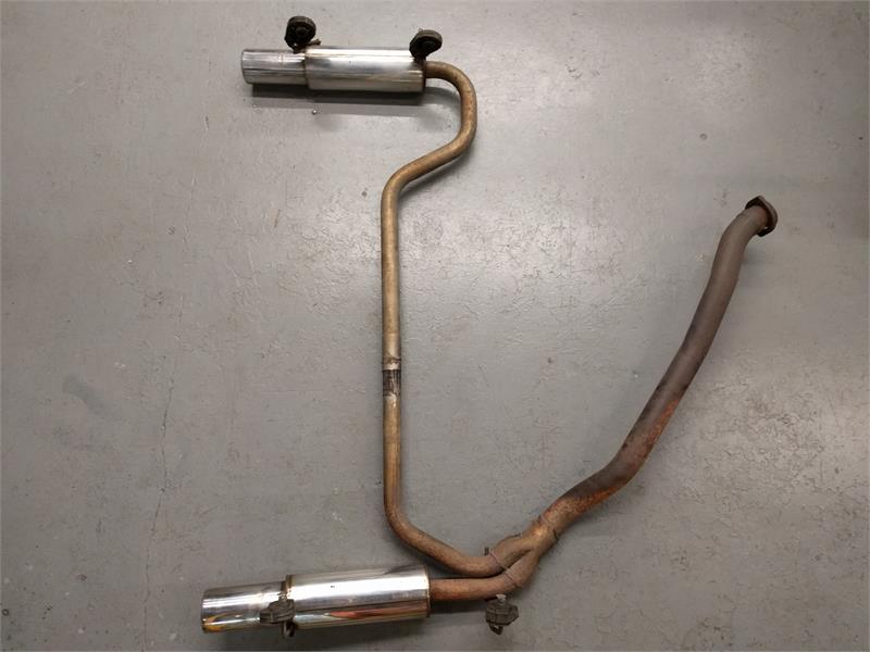 Range Rover Parts dual exhaust system with stainless steel tips and rusted piping on gray floor
