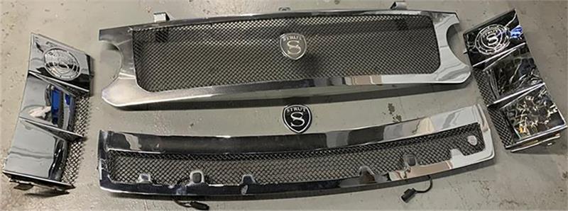 Range Rover parts including chrome and black grille components with strut mounts