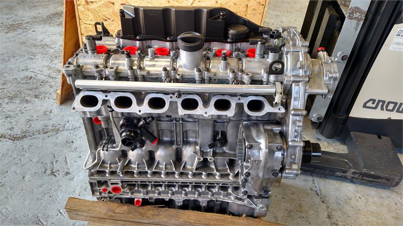 LR2 Parts automotive engine cylinder block with attached components on wooden pallet