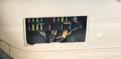 Range Rover fuse box cover removed showing internal wiring and fuses for vehicle electrical system