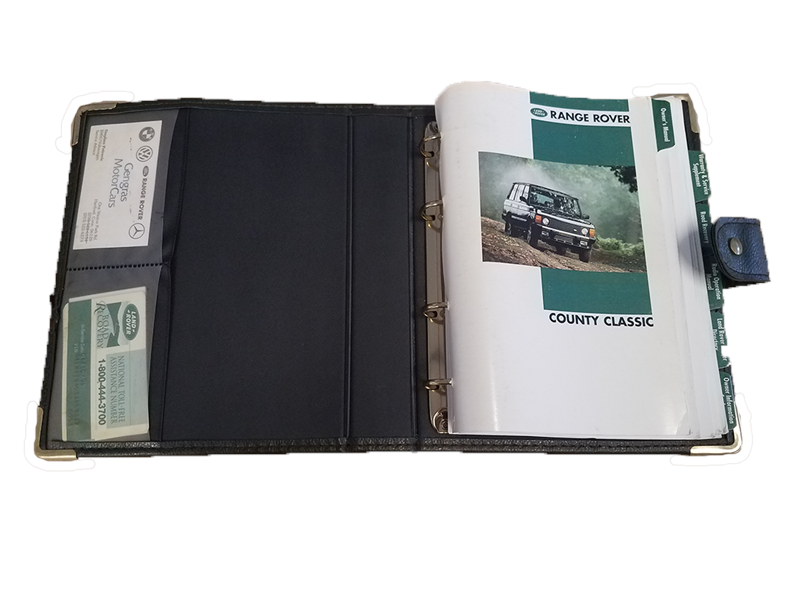 Open Range Rover owners manual binder with County Classic guide and certificate holder